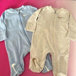 2 zip up Nike onesies.